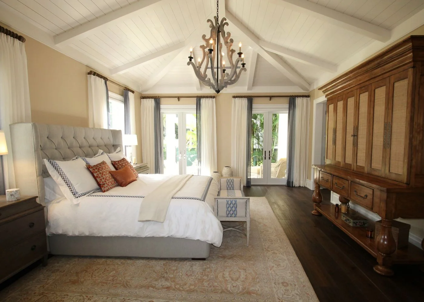 Bedroom with a made bed, a chandelier and timber wall panelling