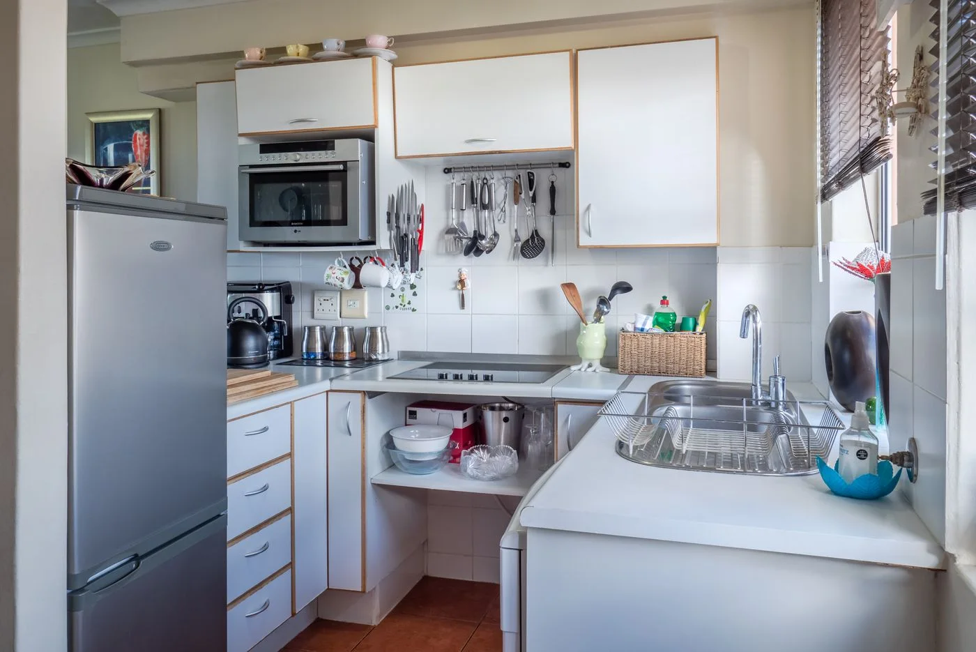 Compact kitchen with white cabinetry and a small counter