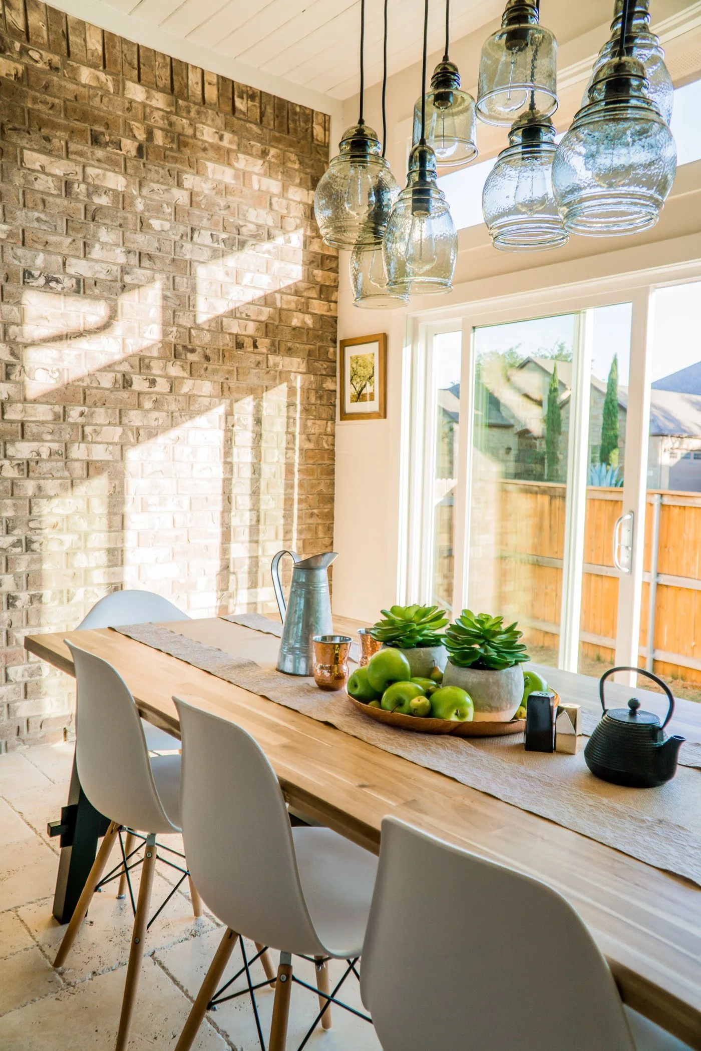 Wooden dining table and chairs beside tall glass doors