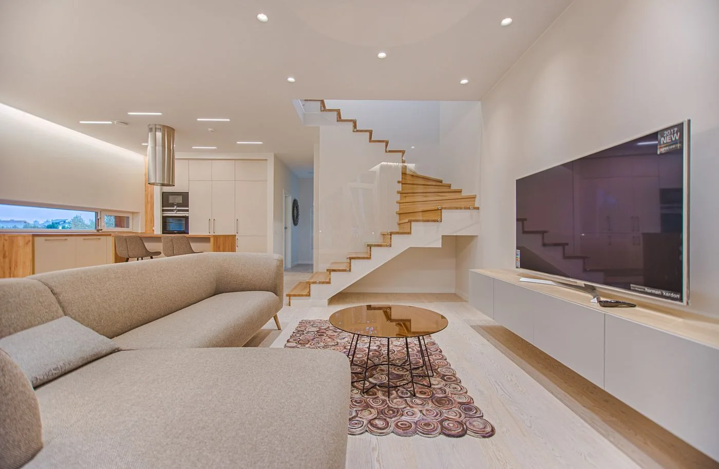 Patterned rug beneath round coffee tables beside a large grey sofa